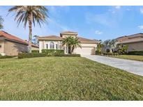 Single-story home with landscaped lawn, driveway, and two palm trees at 13147 Preserve Ct, Port Charlotte, FL 33953