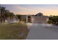 Charming single-story home featuring a 2-car garage, well-maintained lawn, and tropical landscaping at 154 Catamaraca Ct, Punta Gorda, FL 33983