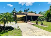 Single-story house with a covered patio and landscaped lawn at 18085 Wintergarden Ave, Port Charlotte, FL 33948