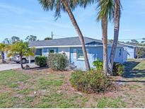 Side view of a light blue home with palm trees and landscaping at 1956 Wyoming Ave # 0, Englewood, FL 34224