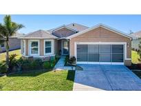 Tan one-story house with a two-car garage and well-maintained lawn at 25281 E Lenox Cir, Punta Gorda, FL 33950