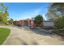 Pink single story home with attached garage and gated entrance at 3360 Conway Blvd, Port Charlotte, FL 33952