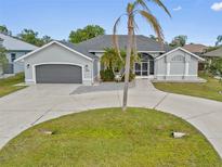 Gray house with palm tree and circular driveway at 474 Orlando Blvd, Port Charlotte, FL 33954