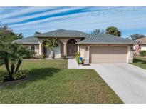 Single-story home with a two-car garage and landscaped lawn at 7543 S Blue Sage, Punta Gorda, FL 33955