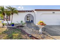 White single-story home with landscaped yard, walkway, and attached garage at 604 Foxwood Blvd, Englewood, FL 34223