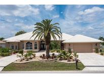 House exterior featuring a tile roof, palm tree, and stone driveway at 920 Via Tripoli, Punta Gorda, FL 33950