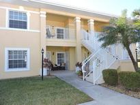 Two-story condo with white railing, lush landscaping and palm tree at 1235 Saxony Cir # 5105, Punta Gorda, FL 33983