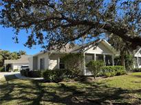 Single-story home with screened porch and mature landscaping at 1577 Red Oak Ln, Port Charlotte, FL 33948