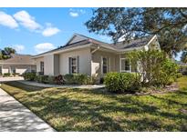 Tan one-story house with green landscaping, screened porch, and walkway at 1577 Red Oak Ln, Port Charlotte, FL 33948