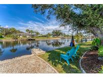 Relaxing waterfront backyard features seating area and canal views at 18390 Burkholder Cir, Port Charlotte, FL 33948