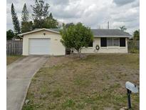 Ranch style home with a single car garage and well-maintained lawn at 2461 Ivanhoe St, Port Charlotte, FL 33952