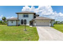 Two-story house with a beige exterior, two-car garage, and lush green lawn at 4630 Fallon Cir, Port Charlotte, FL 33948