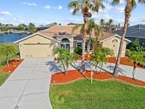 Charming single-story home boasts a lush landscaped front yard and a spacious two-car garage at 1346 Osprey Dr, Punta Gorda, FL 33950