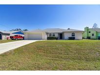 Single-story home with a large front yard and attached garage at 1426 Natrona Dr, North Port, FL 34286