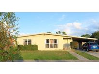 Cute yellow house with a carport and well-manicured lawn at 2544 Elkcam Blvd, Port Charlotte, FL 33952