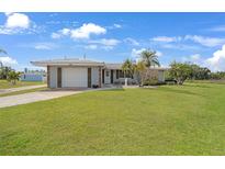 Ranch-style home with attached garage, and spacious lawn at 334 Skylark Nw Ln, Port Charlotte, FL 33952