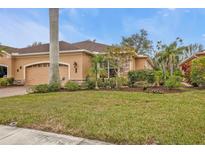 Tan house exterior with attached garage and manicured lawn at 4590 Turnberry Cir, North Port, FL 34288