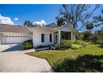 Charming single-story home with a well-manicured front yard and an attached two-car garage at 1407 Red Oak Ln, Port Charlotte, FL 33948