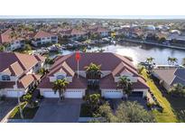 Aerial view of waterfront property showing a luxurious home with private garages and a canal view at 141 Tropicana Dr # 1111, Punta Gorda, FL 33950