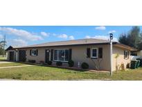 Charming single-story home with a well-manicured lawn, dark shutters, and a neutral color palette at 181 Coconut St, Punta Gorda, FL 33980