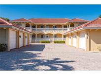 Inviting two-story condo building showcases a red tile roof, white railings, and well-manicured landscaping at 3329 Purple Martin Dr # 113, Punta Gorda, FL 33950