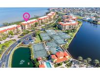 Beautiful aerial view showcasing condos, tennis courts, a pool, and waterfront access in a desirable community at 91 Vivante Blvd # 402/9142, Punta Gorda, FL 33950