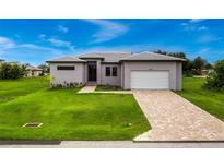 Single-story home with gray exterior, tile roof, and a paved driveway at 17200 Mint Ln, Punta Gorda, FL 33955