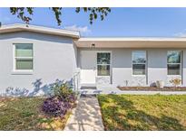 Inviting front entrance with well-maintained landscaping and a freshly painted exterior at 21274 Gladis Ave, Port Charlotte, FL 33952