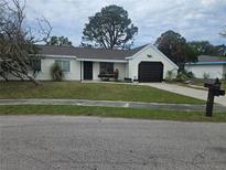 Single-story house with dark brown garage door and well-maintained lawn at 3261 Mill Run Ct, North Port, FL 34287