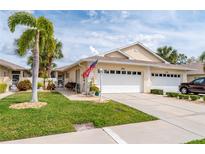Inviting home featuring an attached garage, lush lawn, and mature palm trees at 1706 Fountain View Cir, Venice, FL 34292