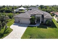 Well maintained, updated, single Gathering home features a spacious three car garage, manicured lawn, and elegant canal access at 17350 Bayharbor Cir, Port Charlotte, FL 33948