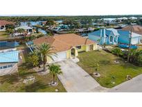 Aerial view of a canal-front home with a spacious yard and detached garage at 3370 Dover Dr, Punta Gorda, FL 33983