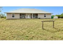 Charming single-story home featuring a metal roof, covered front porch, and ample yard space at 6171 Swiss Blvd, Punta Gorda, FL 33982