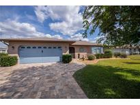 Charming single-story home with a blue garage door, lush lawn, and stone-paved driveway at 1212 Yachtsman Ln, Punta Gorda, FL 33983