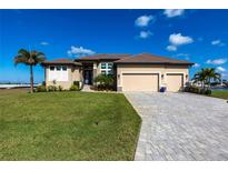 Beautiful single Gathering home with a well-manicured lawn, palm trees, and paved driveway leading to a three car garage at 17122 Barcrest Ln, Punta Gorda, FL 33955