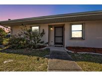 Charming home featuring a cozy front entrance, with beautiful flowering plants and a well-kept lawn at 25068 Harborview Rd # 3B, Punta Gorda, FL 33980