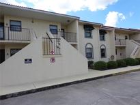 The exterior of the apartments feature balconies, green bushes, and plenty of parking spaces at 26461 Explorer Rd # B, Punta Gorda, FL 33983