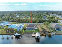 Aerial view of waterfront property featuring a pool, dock, and boat lift at 349 Springview Nw Cir, Port Charlotte, FL 33948