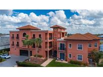 Stunning multi-story building featuring a unique design, a red tile roof and lush tropical landscaping at 1344 Mediterranean Dr # 121, Punta Gorda, FL 33950