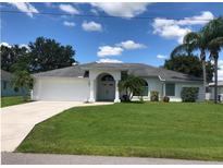 Charming one-story home boasts a well-manicured lawn and an attached two-car garage at 223 Valdiva St, Punta Gorda, FL 33983