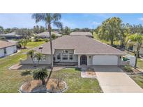 Charming single-story home features a two-car garage, arched windows, mature landscaping and a well maintained lawn at 27566 Tierra Del Fuego Cir, Punta Gorda, FL 33983