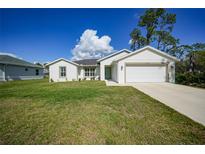 Charming single-story home with a well-manicured lawn and a two-car garage at 23254 Stelling Ave, Port Charlotte, FL 33980