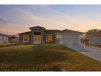 Beautiful single-story home with a well-manicured lawn and attached two-car garage at 2405 Vancouver Ln, North Port, FL 34286