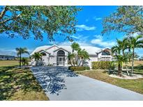 Beautiful home featuring a white metal roof, lush landscaping, and a long private driveway at 24344 Penhollow Ct, Punta Gorda, FL 33955