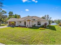 Charming single-story home featuring a well-maintained lawn, colorful landscaping, and an attached two-car garage at 1391 Abalom St, Punta Gorda, FL 33980