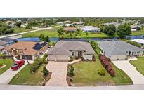 Stunning aerial view of a beautiful home with a well-manicured lawn, brick driveway and a nearby canal at 158 Mariner Ln, Rotonda West, FL 33947