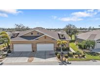Charming tan two-story home featuring a well-manicured lawn and a spacious two-car garage at 24036 Buckingham Way, Port Charlotte, FL 33980