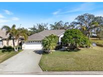 Charming single-story home featuring a two-car garage, lush landscaping, and a well-manicured lawn at 2479 Sonoma Dr W, Nokomis, FL 34275