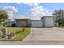 Charming single-Gathering home featuring a metal roof, two-car garage, and well-manicured lawn at 2012 River Basin Ter, Punta Gorda, FL 33982