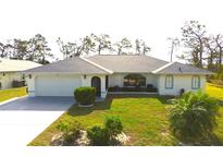 Charming single-story home featuring a well-manicured lawn and mature landscaping with a two car garage at 6170 David Blvd, Port Charlotte, FL 33981